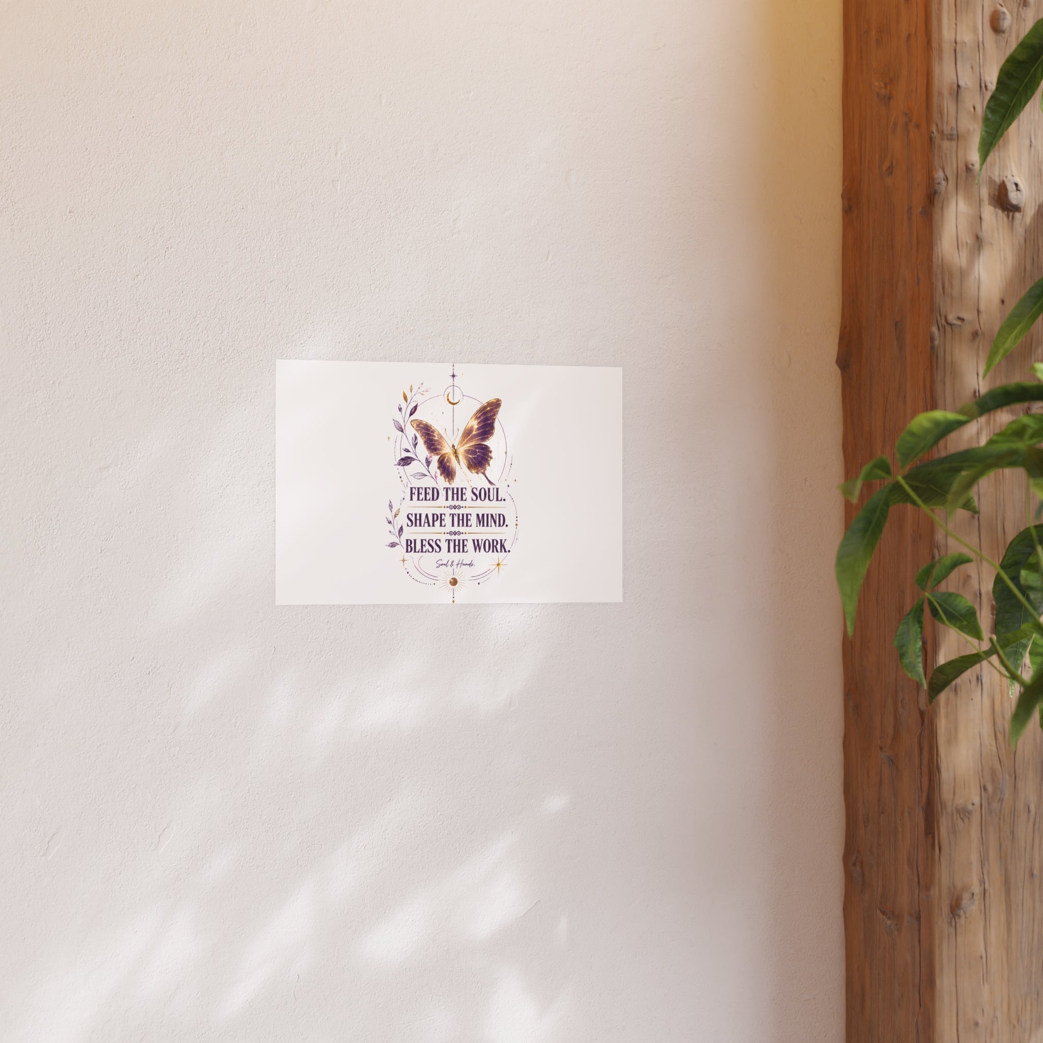 Decorative wall art with butterfly and text on a white background, leaning against a wooden surface.
