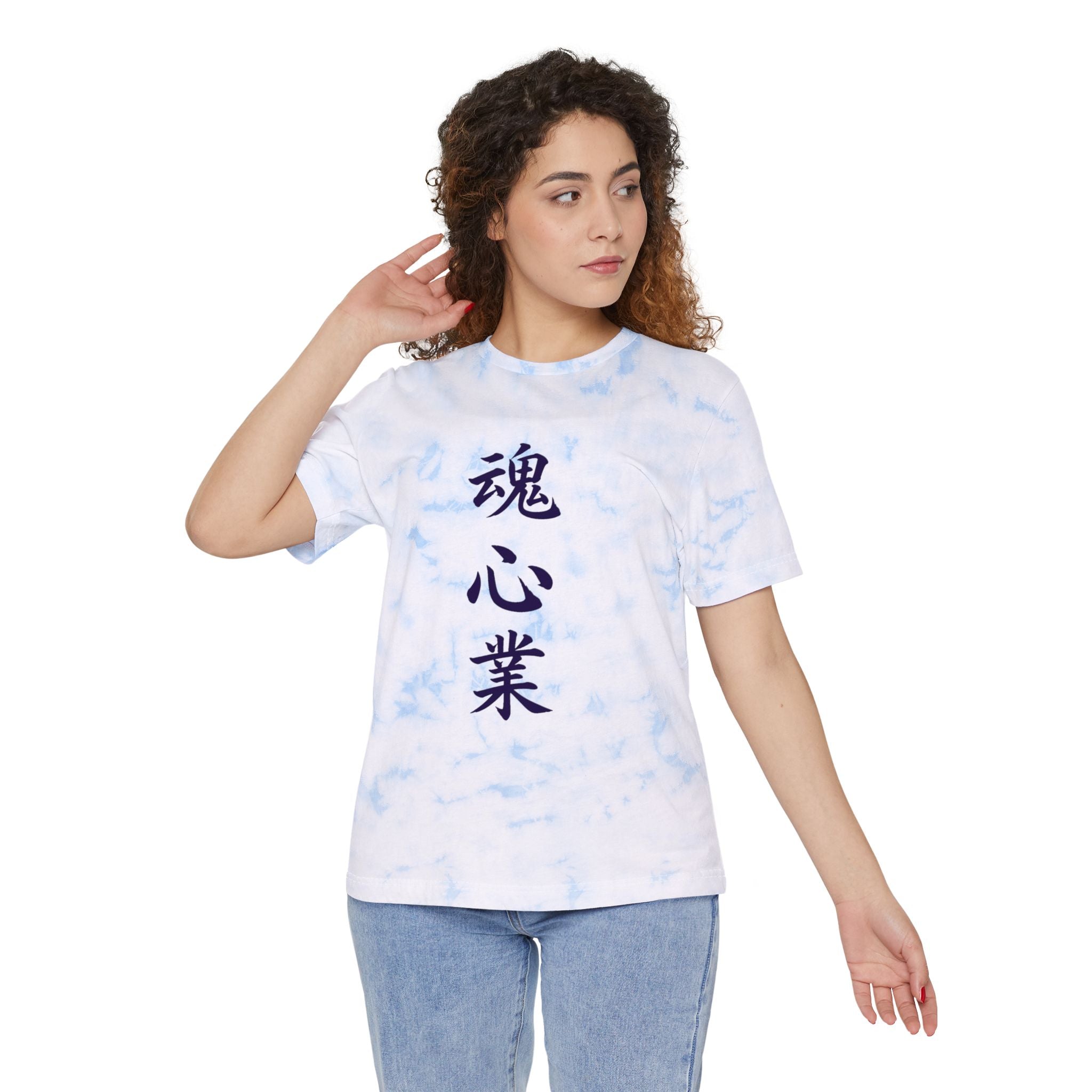 A woman modeling a white short-sleeve t-shirt with a light blue tie-dye pattern and dark blue vertical Japanese characters printed on the front, paired with light blue jeans against a plain white background.