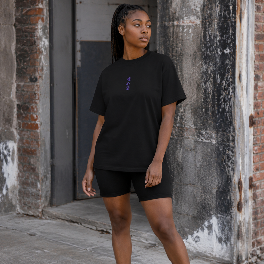 Woman wearing a black Soul & Hands T-shirt with small vertical purple Japanese kanji lettering on the front.