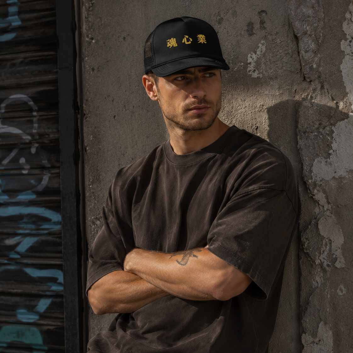 Man wearing a black Soul & Hands trucker cap with bold gold Japanese kanji lettering.
