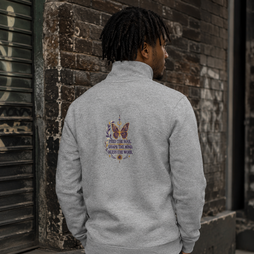 Back view of a man wearing a grey Soul & Hands quarter-zip with a centered butterfly and Feed the Soul graphic.