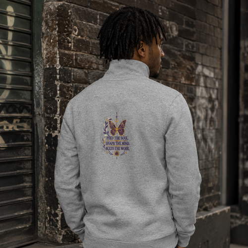 Back view of a man wearing a grey Soul & Hands quarter-zip with a centered butterfly and Feed the Soul graphic.