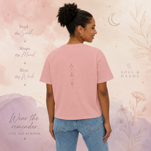Back view of a woman wearing a peach-pink Soul & Hands boxy T-shirt with a small vertical botanical motif.