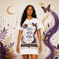 Front view of a woman wearing a white Soul & Hands T-shirt dress with purple-and-gold celestial, butterfly and botanical artwork.