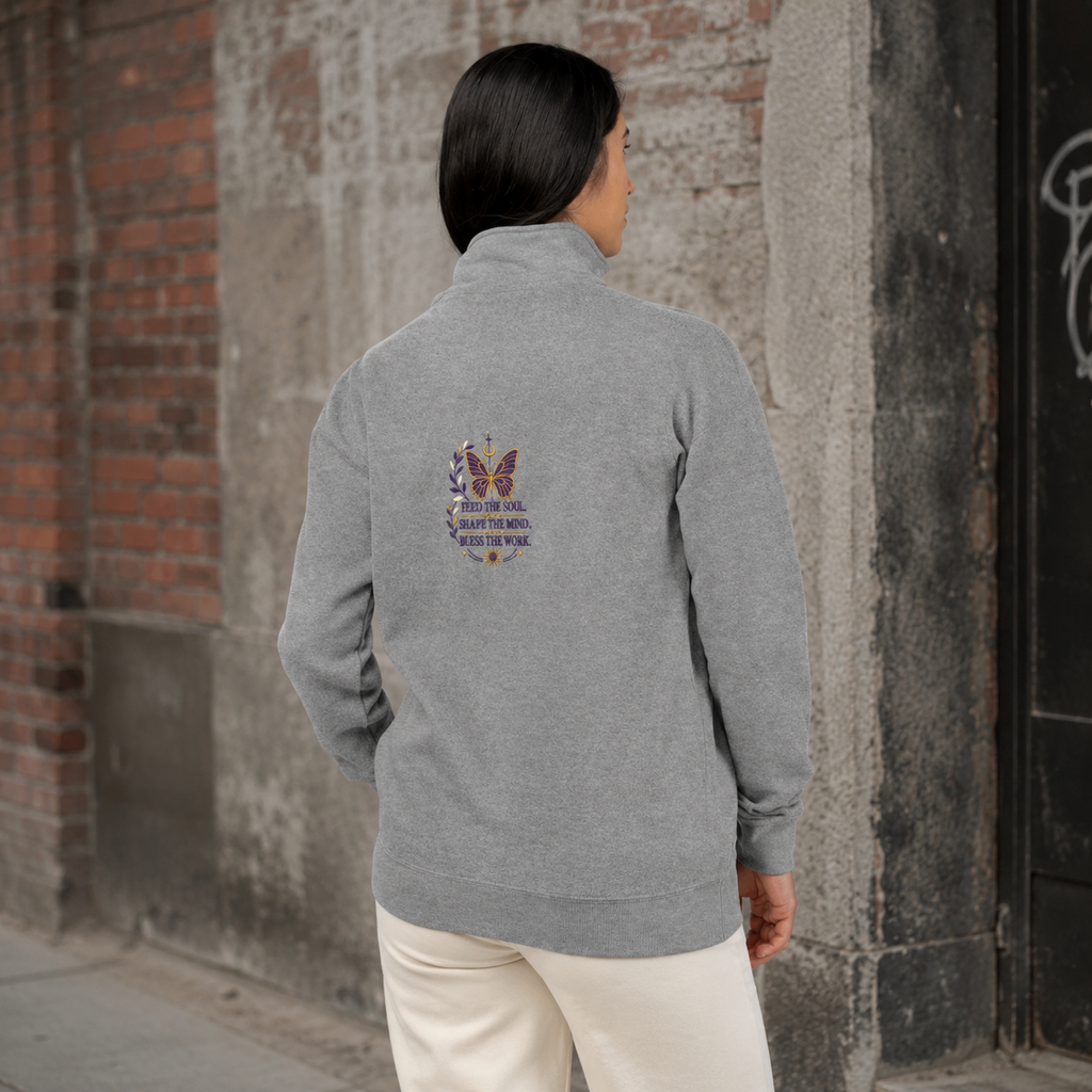 Back view of a woman wearing a grey Soul & Hands quarter-zip with a purple-and-gold butterfly and inspirational graphic.