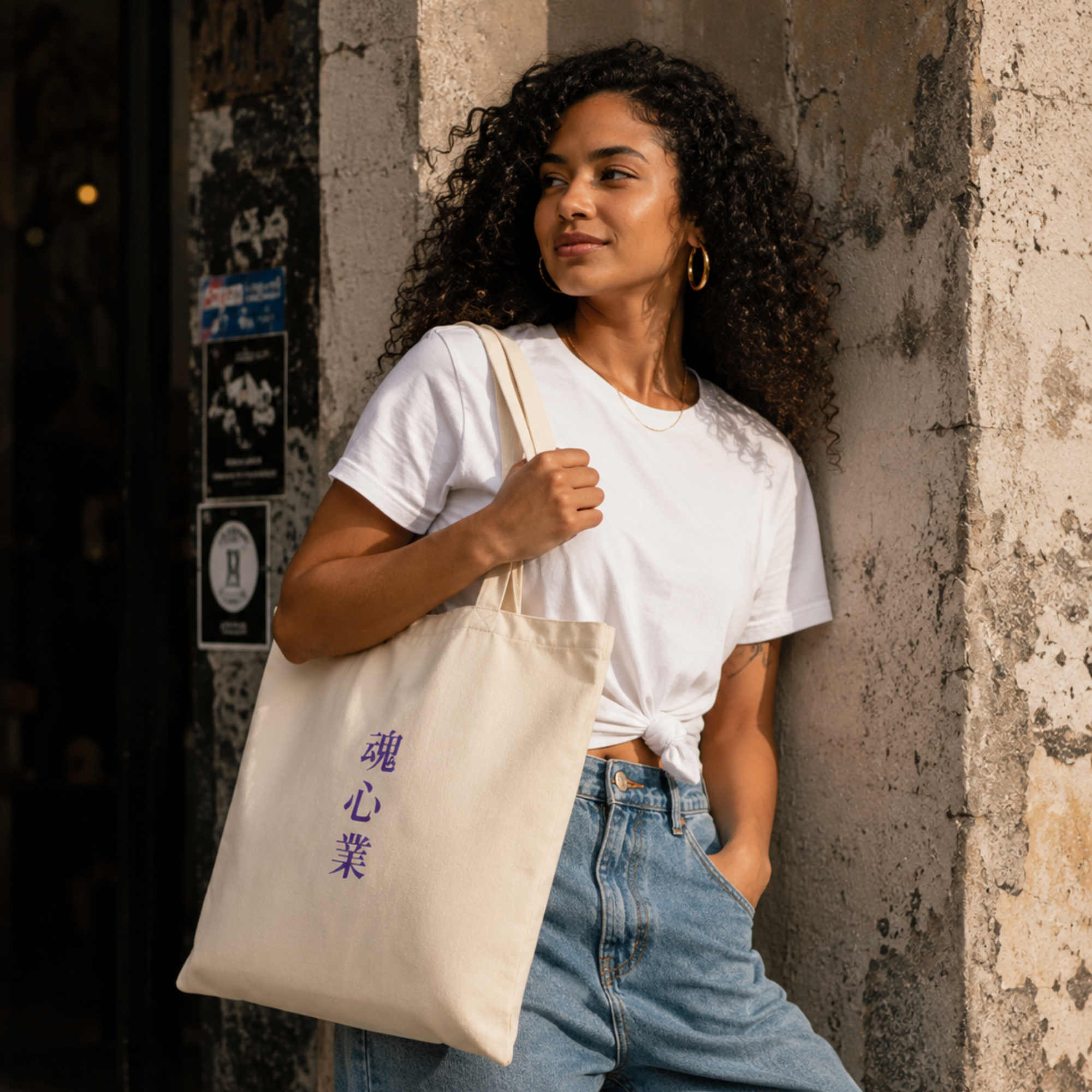 Woman carrying a natural Soul & Hands canvas tote bag with vertical purple Japanese kanji lettering.