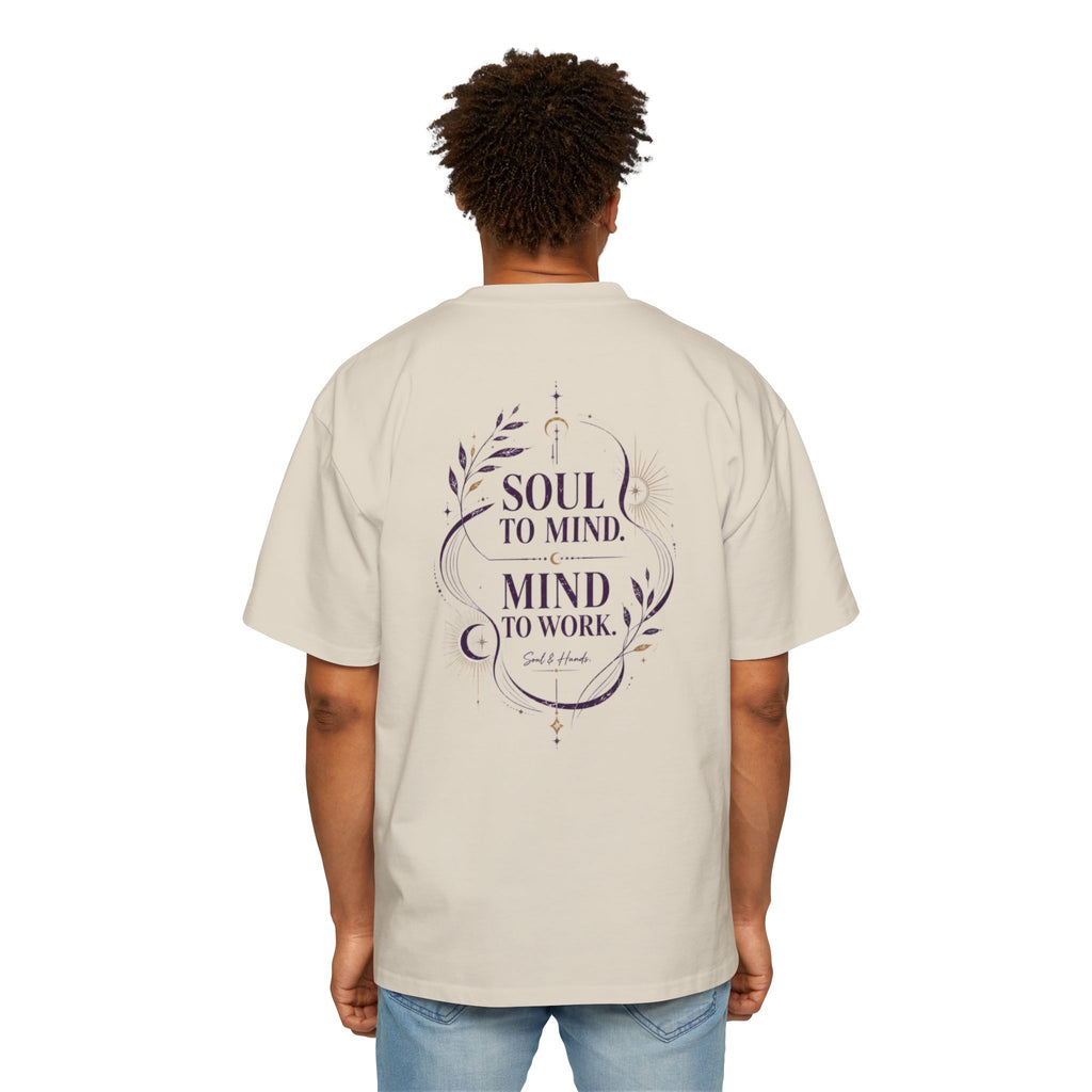 Person wearing a beige t-shirt with a motivational quote on the back, standing against a white background.