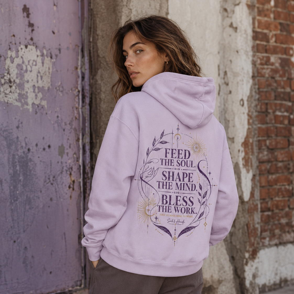 Back view of a lavender Soul & Hands hoodie with purple-and-gold Feed the Soul botanical and celestial artwork.