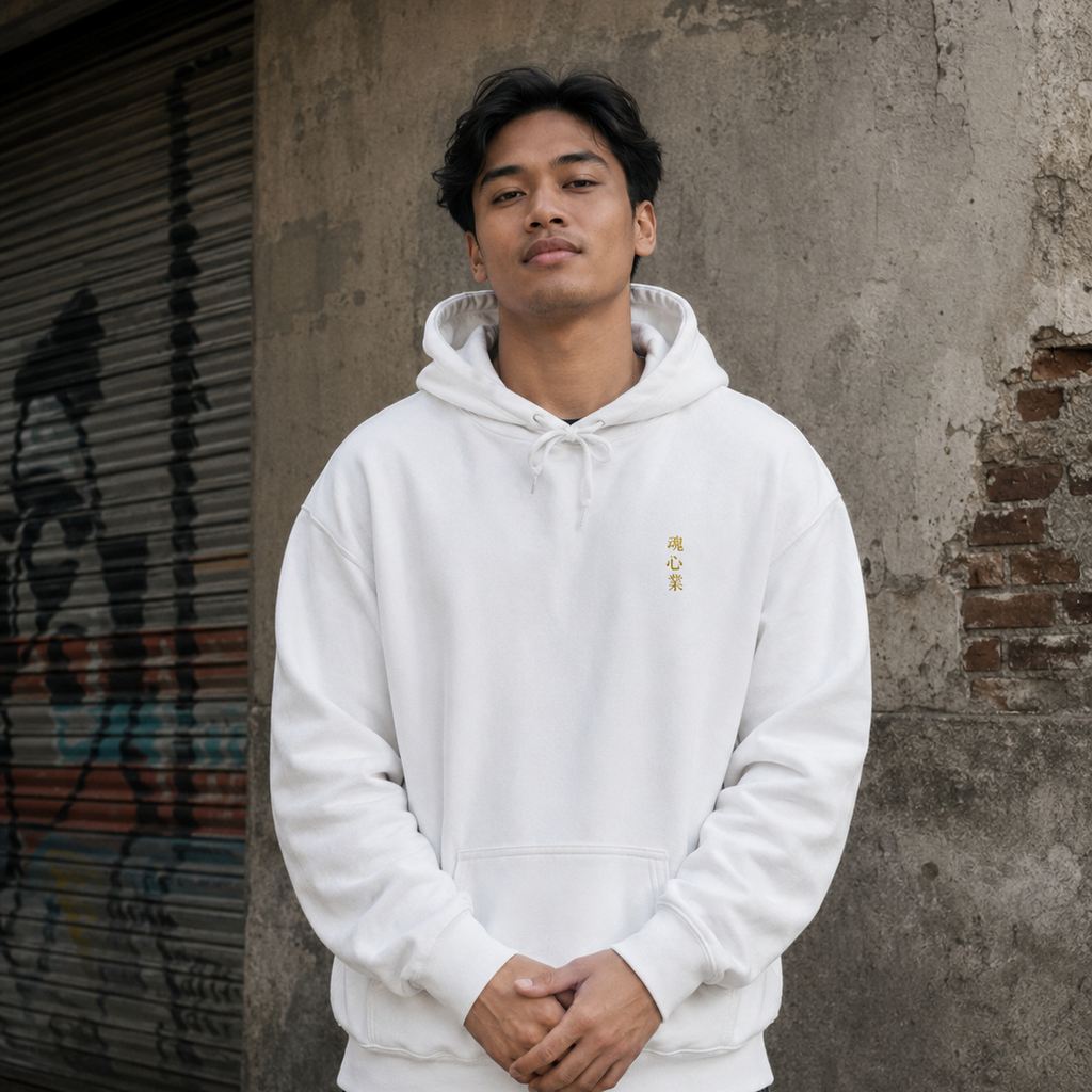 Man wearing a white Soul & Hands hoodie featuring small vertical gold Japanese kanji lettering on the front.
