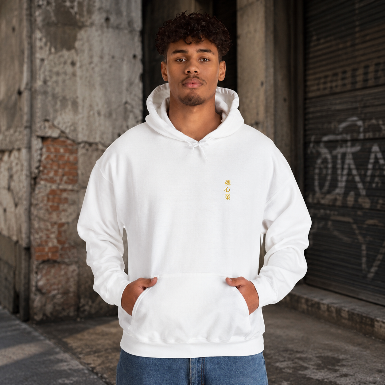 Man wearing a white Soul & Hands hoodie with small vertical gold Japanese kanji lettering on the chest.